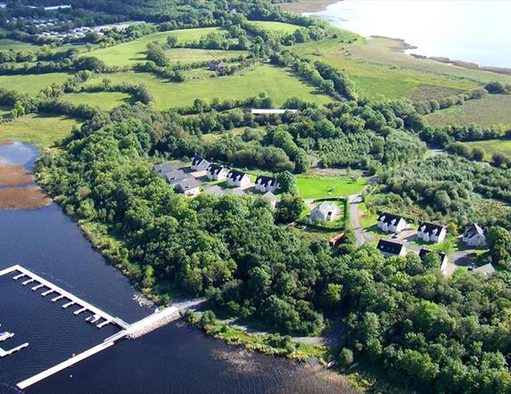 Aerial site photograph of green site with marina in lake