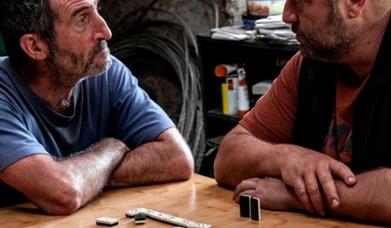 2 men playing dominoes