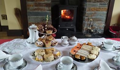 A table laid with plates of cakes and sandwiches