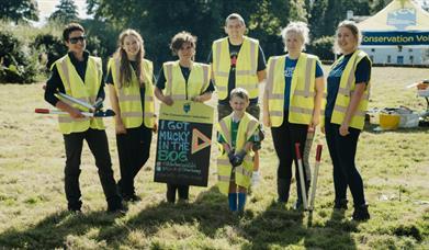 a group of people standing beside the bog at the folk park