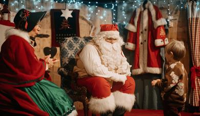Father Christmas and Mrs Claus speaking to a young boy at Ulster American Folk Park