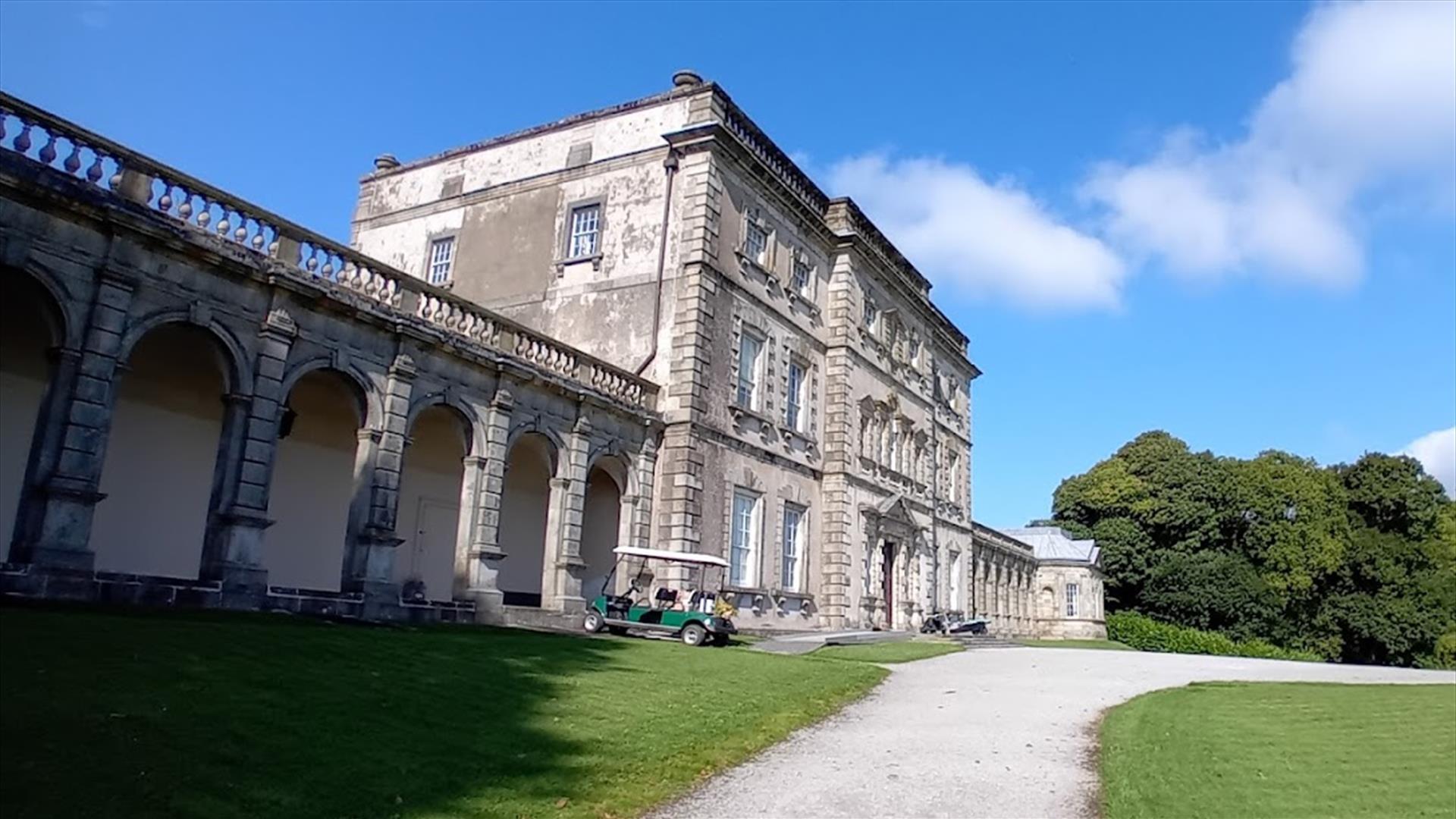 Florence Court House in County Fermanagh with landscaped gardens and surrounding countryside on a clear day.