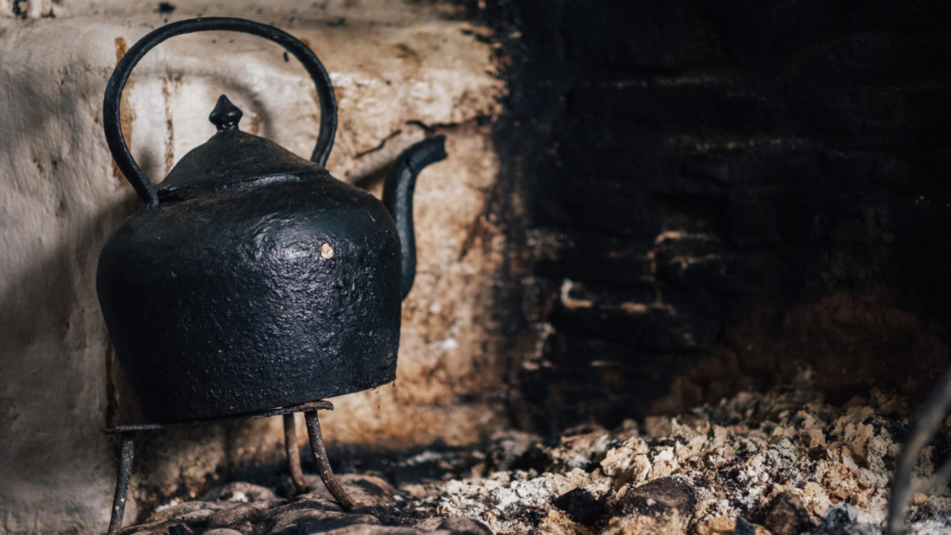 Image of a teapot on the hearth in a cottage at the Ulster American Folk Park