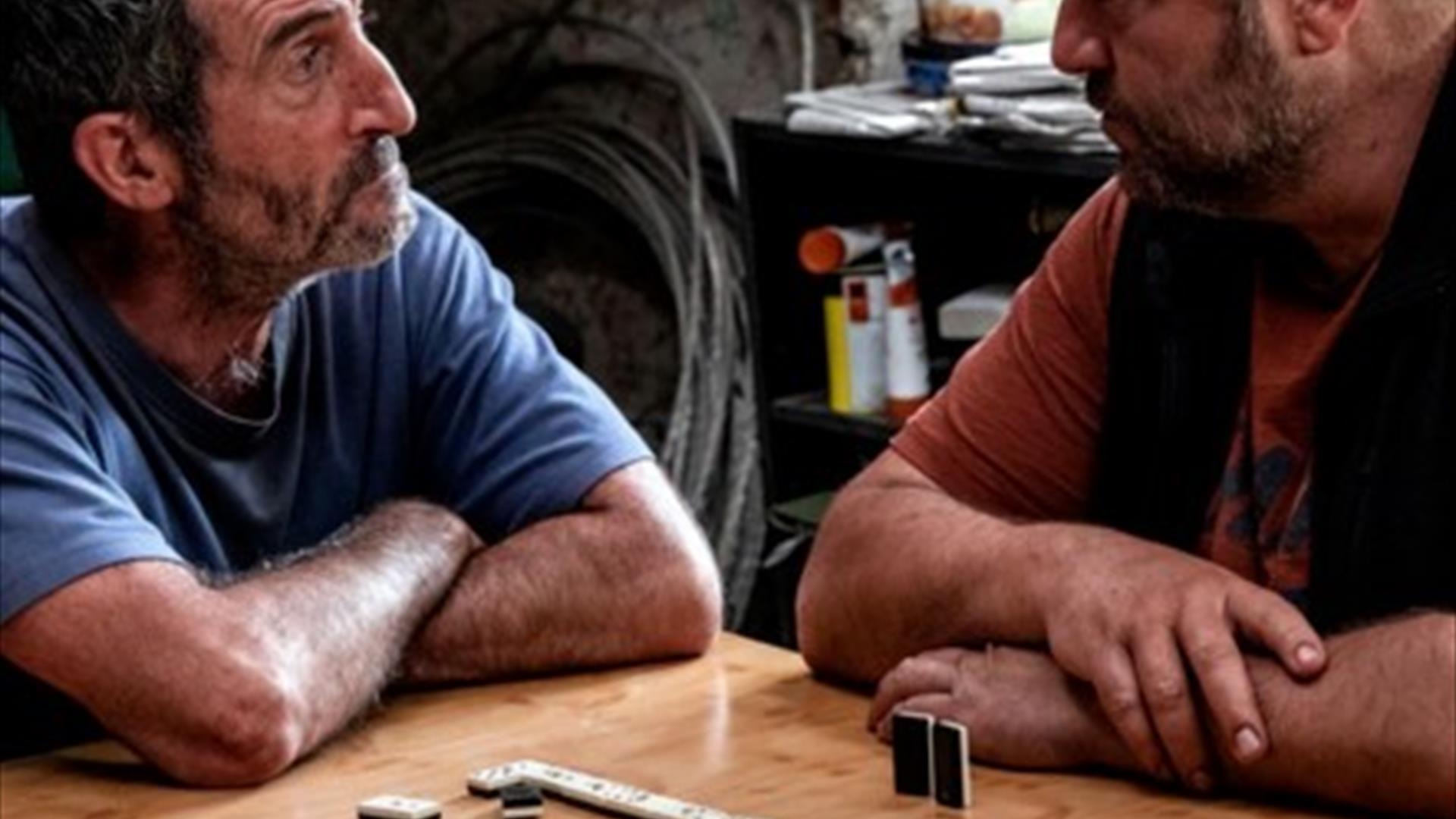 2 men playing dominoes