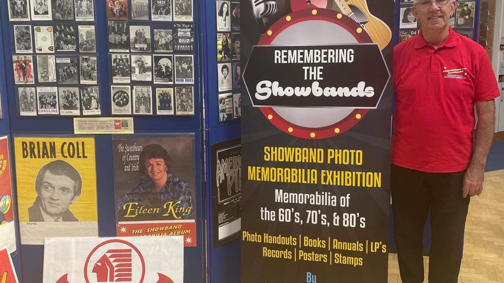 Photo of Philip D'arcy standing beside exhibition title
