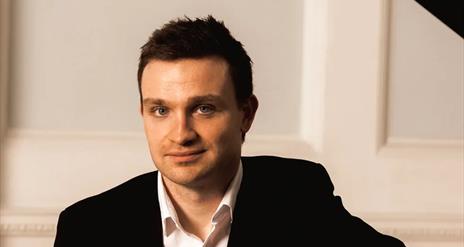 Northern Ireland pianist Cahal Masterson sits at grand piano