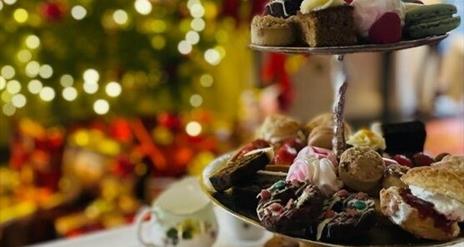 A close up of an afternoon tea with a Christmas tree in the background