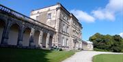 Florence Court House in County Fermanagh with landscaped gardens and surrounding countryside on a clear day.