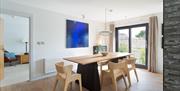 Bright dining room with wooden table and chairs beside large patio doors