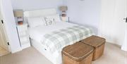 bedroom double bed with side tables and baskets