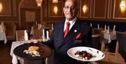 A smiling waiter presenting delicious food