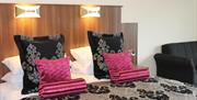 A double bed with patterned pillows and throw