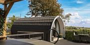 Glamping pod viewed from a private deck with countryside views and outdoor seating.
