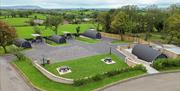 Aerial view of Coolaness Glamping site with pod cabins, private outdoor areas, and surrounding countryside.
