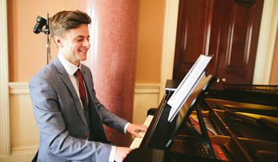 Jonathan Beatty, playing the piano in the Entrance Hall at Castle Coole