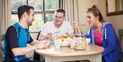 3 people eating at table in apartments and talking happily