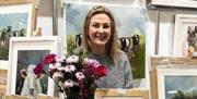 Local craft maker Catherine Swan surrounded by framed pictures