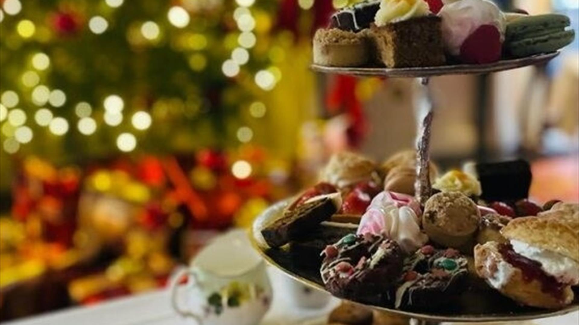 A close up of an afternoon tea with a Christmas tree in the background