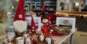 Christmas gifts and ceramics displayed on table inside gift shop area