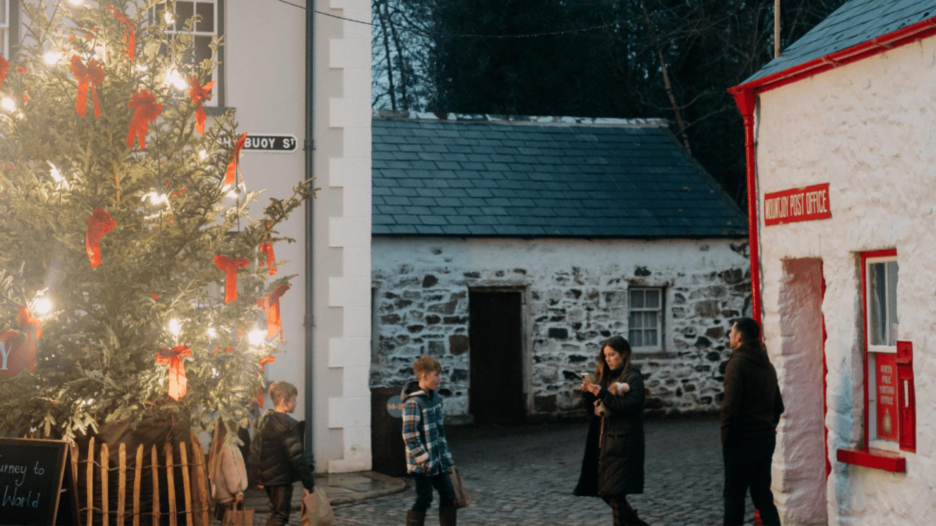 A family of four walking in the Folk Park at Christmas