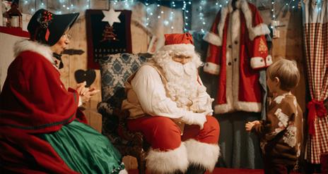 Father Christmas and Mrs Claus speaking to a young boy at Ulster American Folk Park
